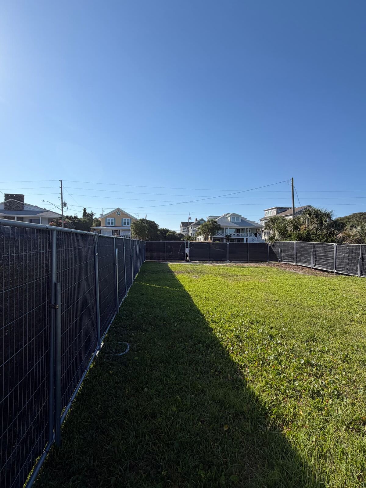 Temporary fence panels installed along a grassy property line