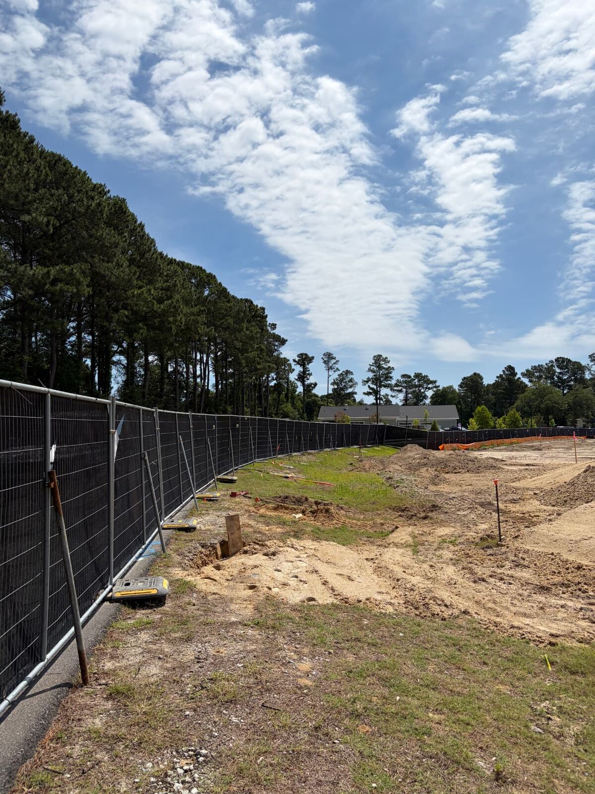 Long run of temporary chain-link fence around a cleared construction lot